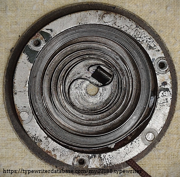 Spring drum opened, showing broken end of spring and sigmoidal bend of spring.