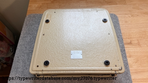 Bottom of typewriter. It looks like one of the feet has been replaced with a rubber grommet. Some letters and numbers were engraved by a previous owner.