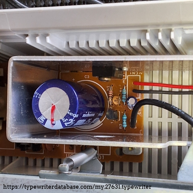 The power transistor is mounted on a nice alu heatsink. You can also see the spring that puts tension on the paper pan rollers.