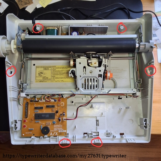 The four points that must be released in order the remove the cover.  The two holes in the back are for Philips screws.