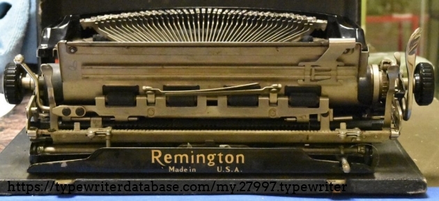 The rod on the lower right gets pushed in when the case is closed with the lid.  It will disengage the shift lock so that it is impossible to close the case with the shift lock engaged.