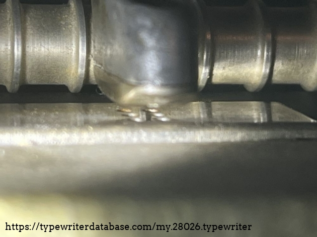 Detail: stripper plate; under the embossing head in upper position, you can see the six holes where the core braille keys appear while typing