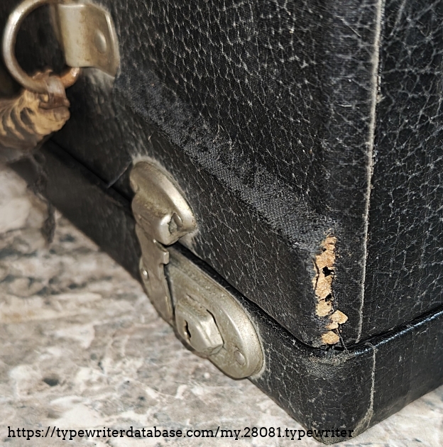 Case detail, showing it was cracked in transit.  There was not much insulation between the inner box, containing the typewriter in its case, and the outer box.  The eBay listing photos show that it was not cracked before shipment.  I just applied some wood glue and the case is now more or less okay.