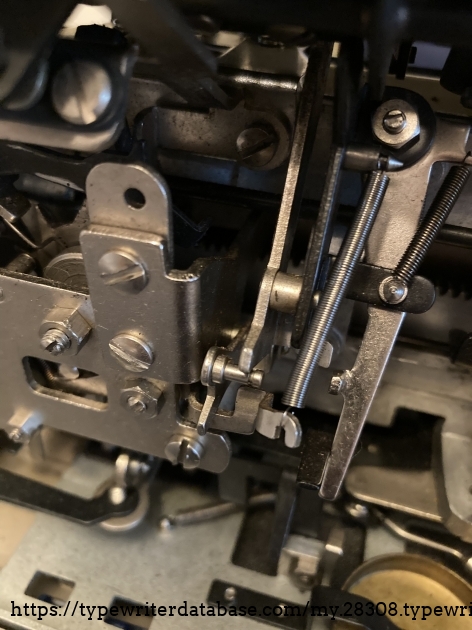 Long side mounted trip return spring.