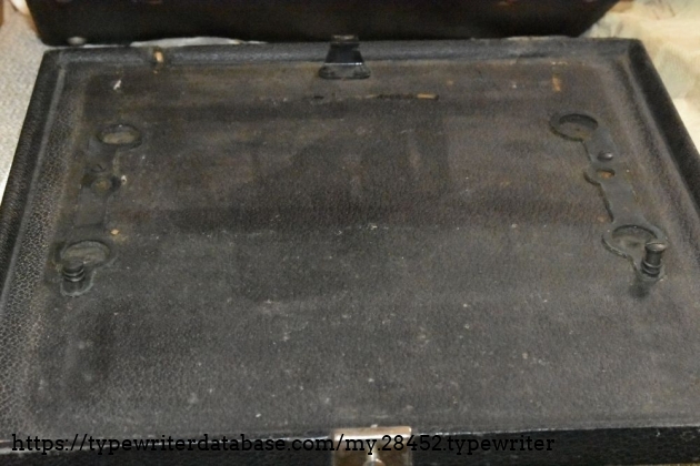 The case bottom.  There's the hook on the back, indentations for the typewriter feet, and the screws that attach the typewriter to the case bottom.
