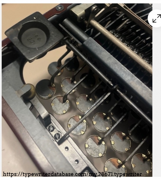 Underside front, under keyboard.