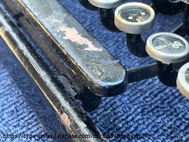 Paint cracked on the spacebar down to the metal, which is what it is made of (not wood).