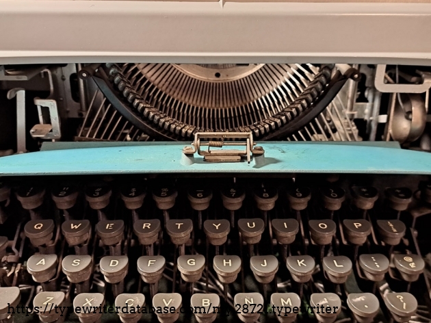 Behind the front cover, access to the touch-control, ribbon direction, and type slugs for cleaning.