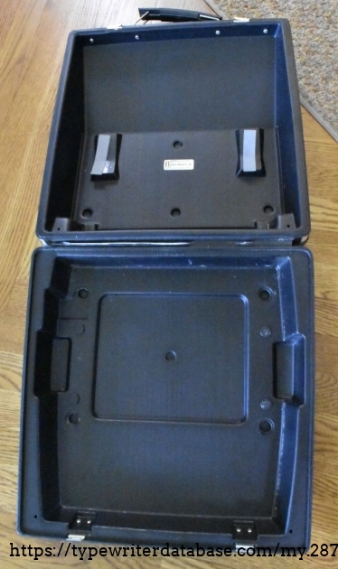 The case relies on the feet fitting into molded indentations, and the top pressing down to immobilize the typewriter within the case.  The carriage return lever is spring loaded so it can press down.  Note the crack in the hinge area - the hinge is just an extension of the molded plastic, and the flexing has caused it to crack.  It has been reinforced with some tape.