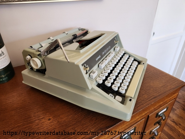 Oblique angle from above the left side of a green Hermes 3000 typewriter