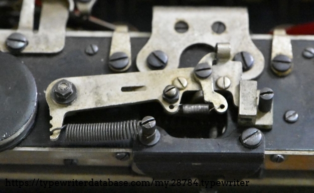 A shot of the escapement.  This arrangement with the spring running along the carriage is different than what's on most service manuals, that have a different arrangement with the spring running vertically. 
Underneath the middle there are the loose and rigid dogs.  The loose dog on this is about a millimeter short, and it looks like it had broken off.