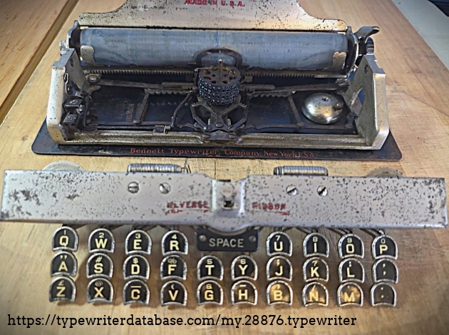Detached keyboard in front of machine.