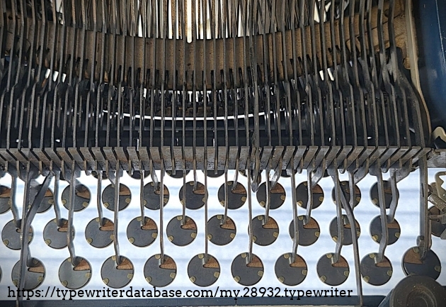 Underside forward, under the keyboard.