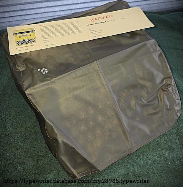 Front-left view with dust cover deployed, and user guide on top.