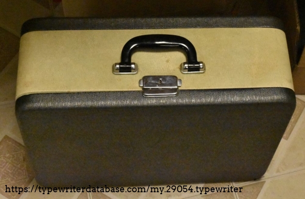 The vinyl-covered square wood type case, in fair shape.  This one is extra wide to accomodate the wide platen.