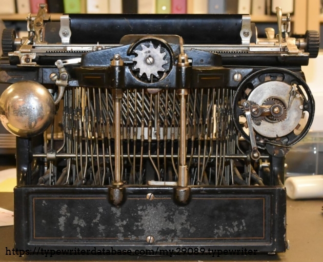 The spring motor is on the right, the bell on the left, and the escapement is top center.  The left center column is the carriage advance, and the right center column is the margin sensor.  Note the small lever on the right column - when the right margin is reached, that lever engages the carriage advance, resulting in the line lock feature which stops you from typing more characters.