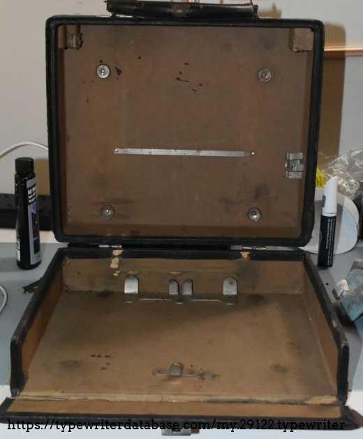Missing the brush and oil can that are held in place by the brackets on the right.  The metal buttons on the lid should have cork and helps keep the typewriter in place.  Will likely replace with felt for furniture feet.