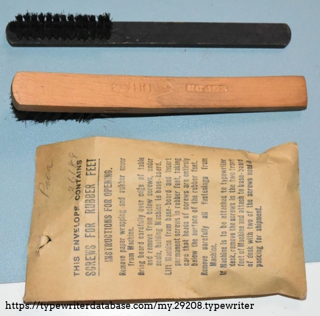 Came with some stuff.  The top brush is L.C. Smith branded.  The middle brush is an Osborn No. 153 brush, the the paper envelope has what seemed to have been the screws used in the original crate the typewriter came in, as well as some extra screws for affixing the rubber feet.