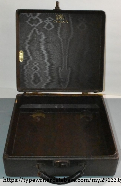 The oddball case, where the thinner 'lid' is actually the lid.  Note the metal plate to hold down the carriage return lever, and the Corona branding.  The deeper bottom has the hardware to affix the typewriter - you hook the front under a metal tab, and the rear brackets hold the rear frame in position, and a pad on the lid holds the platen down.