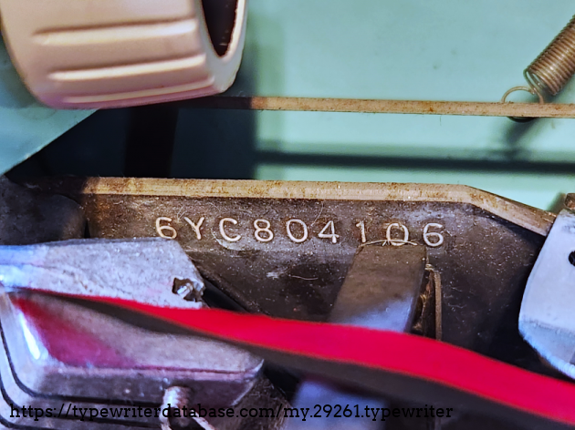 6YC804106, located next to the type segment, to the right. Next to the typebar rest mount.