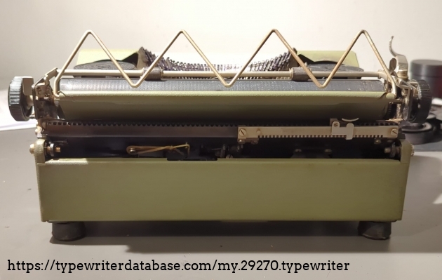 Back of the machine. It has no bell or back stop, only for the starting line. You can also see the rubber band used to replace the missing backspace spring.