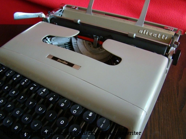 Embossed "OLIVETTI" chrome letters on the paper table