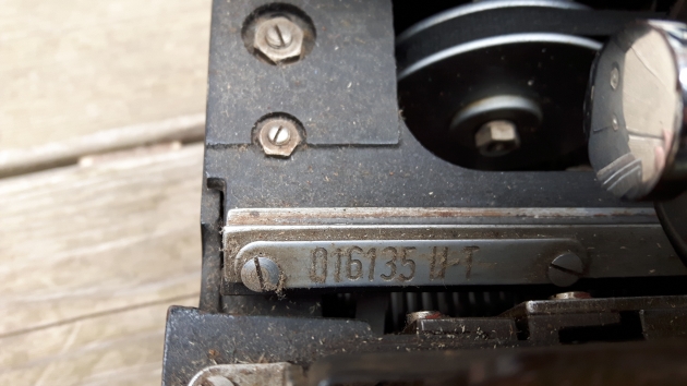 The serial number is under the ribbon cover, on the left.