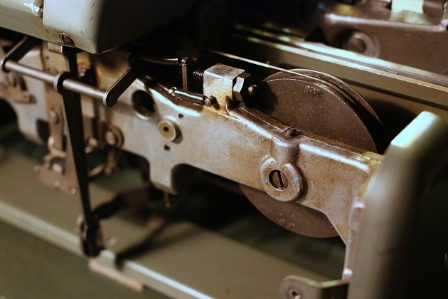 The mainspring wheel, under the carriage. To its left the stop that, together with another one on the other end of the machine, sets the line lock (see next image)